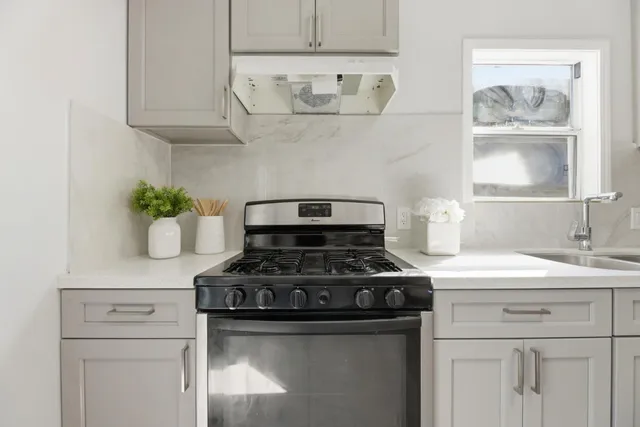 a white stove top oven sitting inside of a kitchen