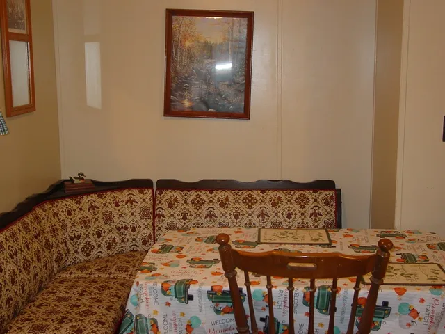 a bed sitting in a bedroom next to a window with wooden floor