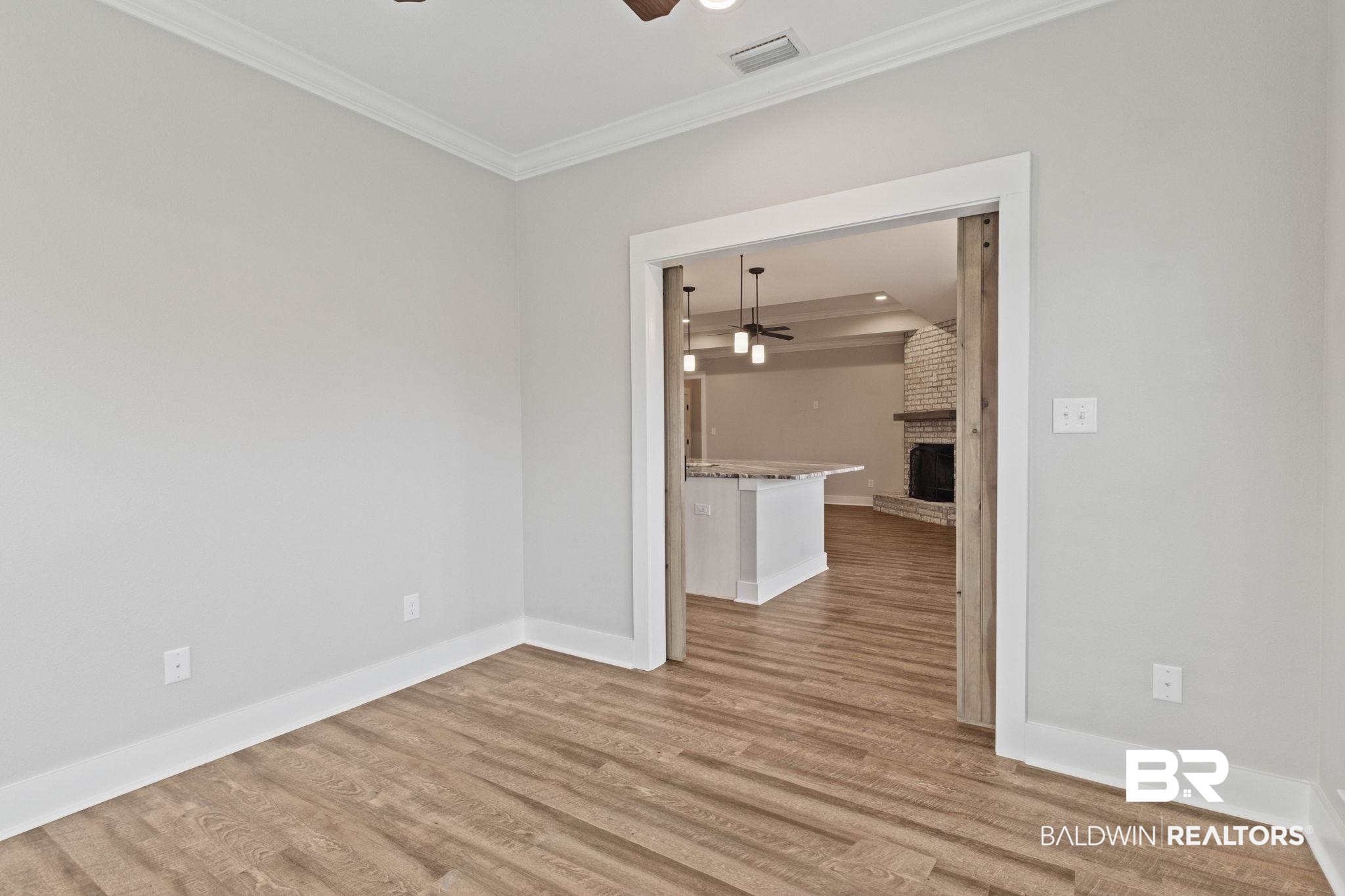 17376 Bankhead Boulevard Fairhope, AL 36532 - Photo 34 of 73 Spare room with a ceiling fan, a brick fireplace, light wood-type flooring, ornamental molding, and recessed lighting