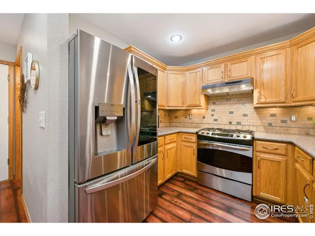 a kitchen with stainless steel appliances granite countertop a refrigerator and a stove