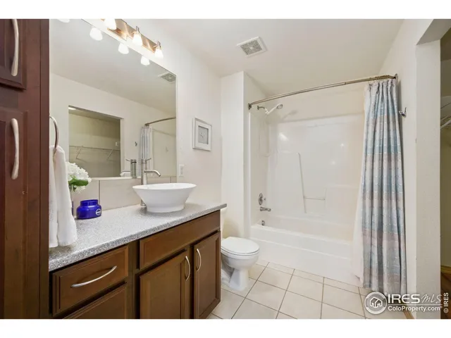 a bathroom with a granite countertop sink a mirror a bathtub and shower