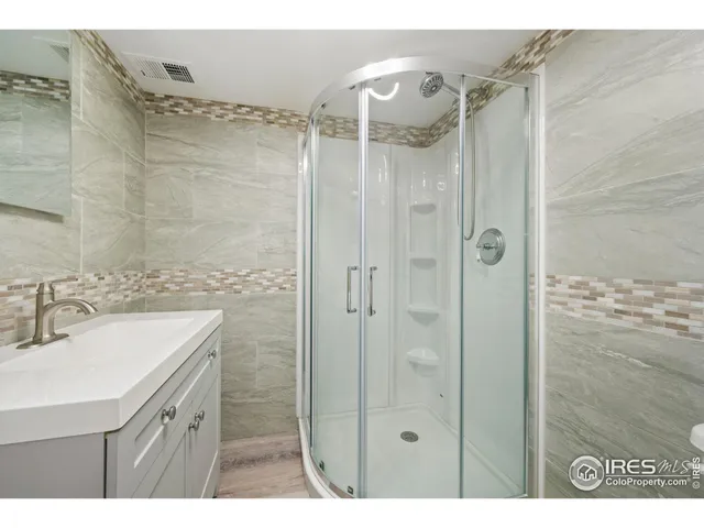 a bathroom with a shower sink and mirror