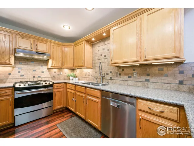a kitchen with stainless steel appliances granite countertop a sink stove and cabinets