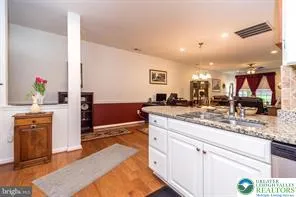 a kitchen with stainless steel appliances granite countertop a sink and a stove top oven
