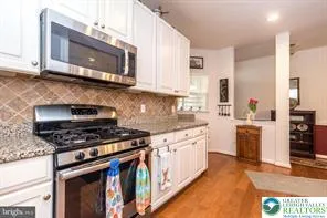 a kitchen with stainless steel appliances wooden cabinets and a stove top oven