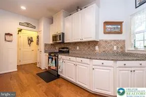 a kitchen with granite countertop a stove a sink and a microwave