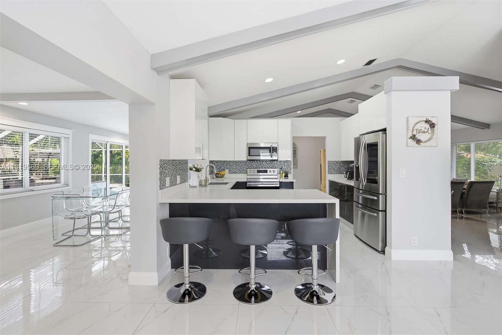 5601 Southwest 195th Terrace Southwest Ranches, FL 33332 - Photo 21 of 84 a kitchen with stainless steel appliances kitchen island granite countertop a table and chairs in it
