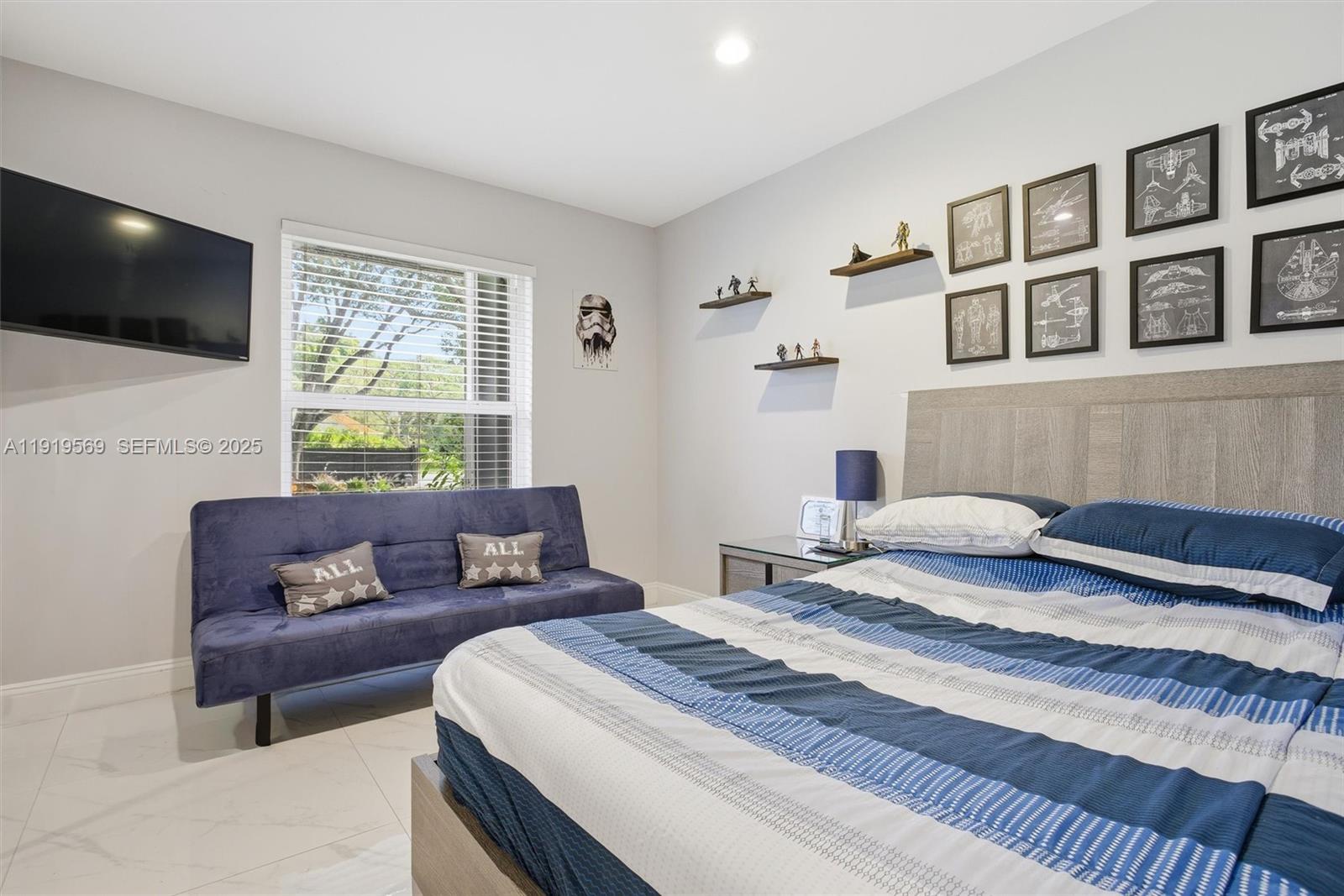 5601 Southwest 195th Terrace Southwest Ranches, FL 33332 - Photo 39 of 84 a bedroom with a bed a couch and a flat screen tv