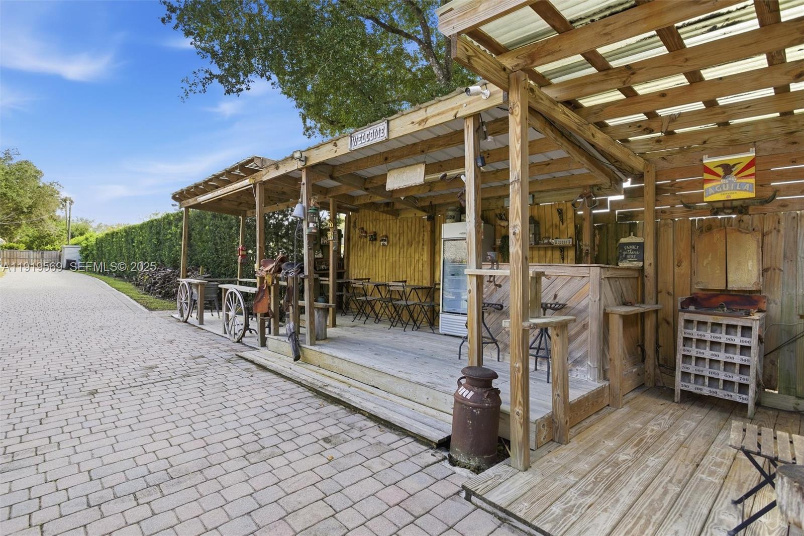 5601 Southwest 195th Terrace Southwest Ranches, FL 33332 - Photo 65 of 84 a view of a patio with table and chairs with wooden floor and fence