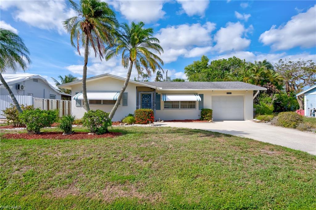 front view of a house with a yard and a garage