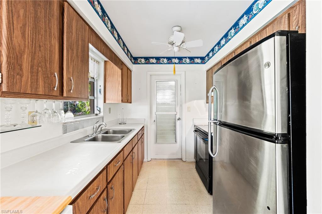 4815 Cortez Circle Naples, FL 34112 - Photo 14 of 31 a kitchen with a refrigerator a sink and cabinets