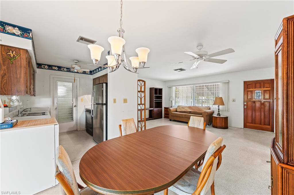 4815 Cortez Circle Naples, FL 34112 - Photo 17 of 31 a living room with furniture a chandelier and a dining table