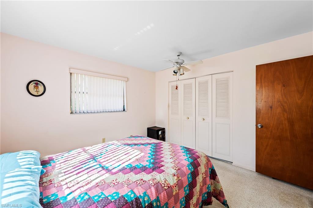 4815 Cortez Circle Naples, FL 34112 - Photo 19 of 31 a bedroom with a bed and a lamp