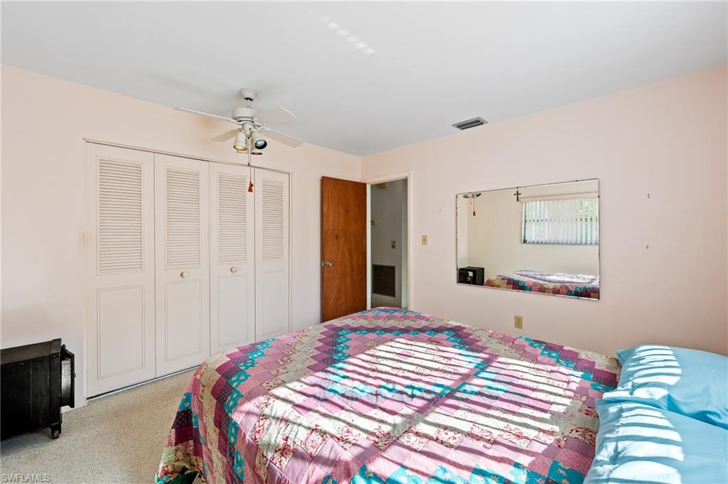 4815 Cortez Circle Naples, FL 34112 - Photo 20 of 31 a bedroom with a bed and a chandelier