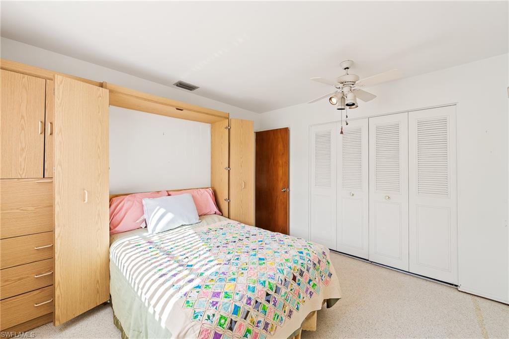 4815 Cortez Circle Naples, FL 34112 - Photo 25 of 31 a bedroom with a bed and a chandelier