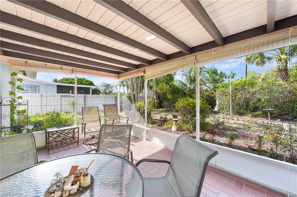 4815 Cortez Circle Naples, FL 34112 - Photo 28 of 31 a living room with patio furniture and a floor to ceiling window