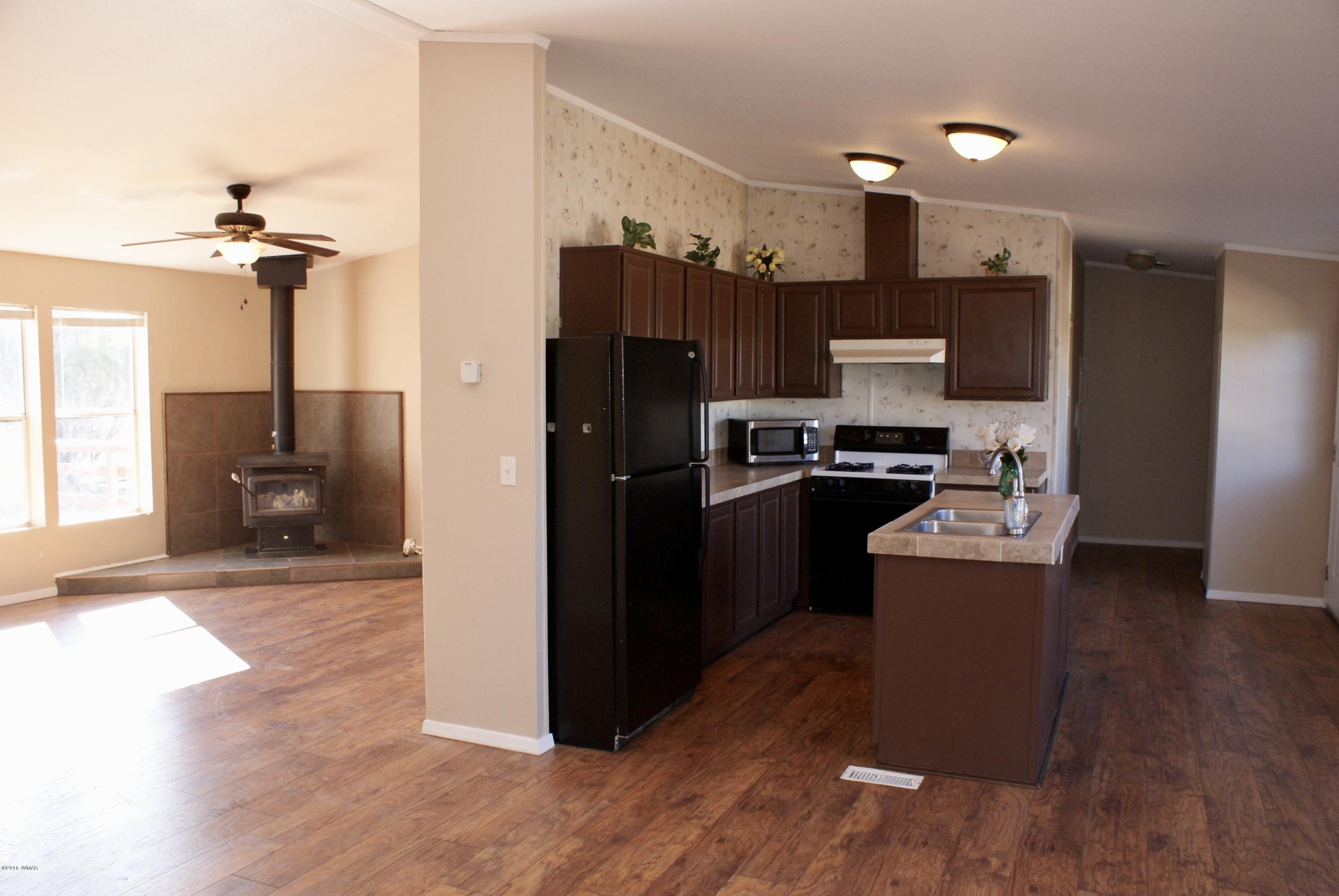 Lot 66 Antelope Vernon, AZ 85940 - Photo 4 of 17 a kitchen with kitchen island wooden floor cabinets and appliances