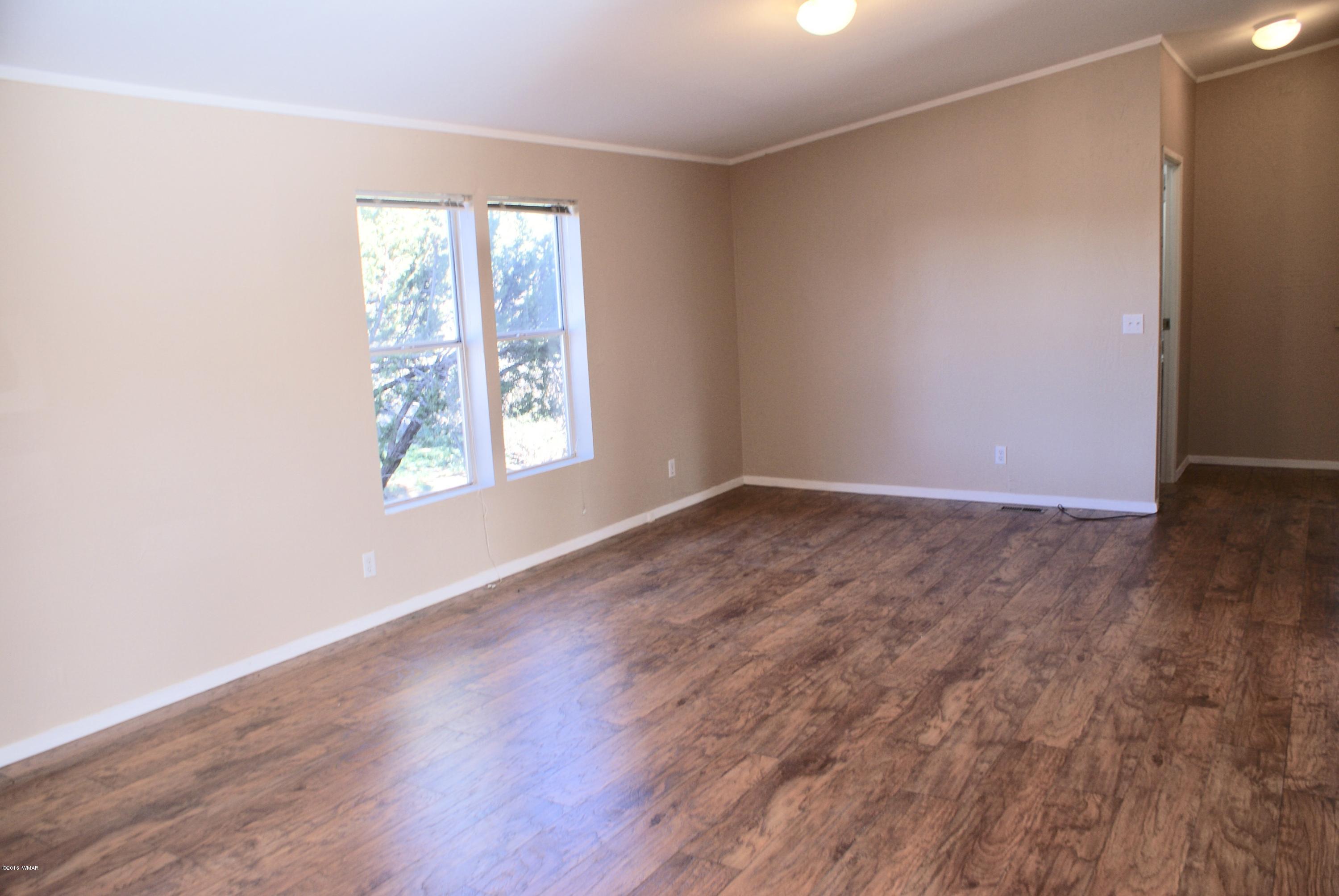 Lot 66 Antelope Vernon, AZ 85940 - Photo 7 of 17 an empty room with wooden floor and windows