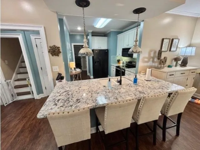 a kitchen with stainless steel appliances kitchen island granite countertop a table chairs and wooden floor