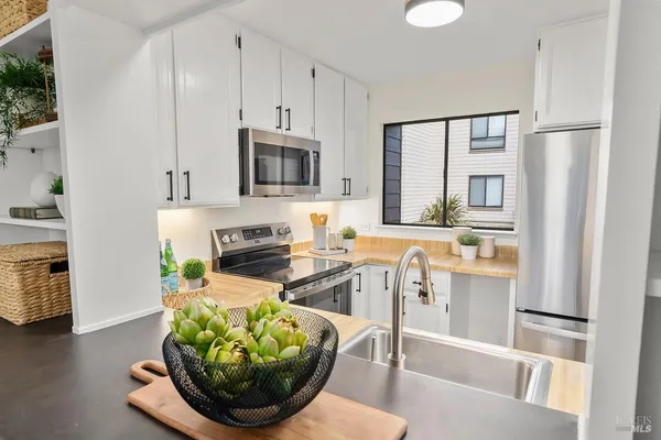 a kitchen with stainless steel appliances a dining table a stove a microwave and cabinets