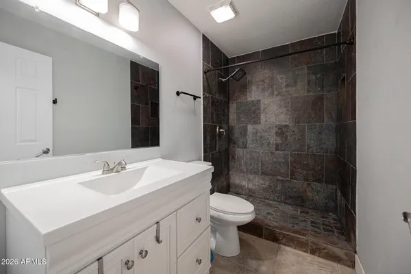 a bathroom with a sink mirror toilet and shower