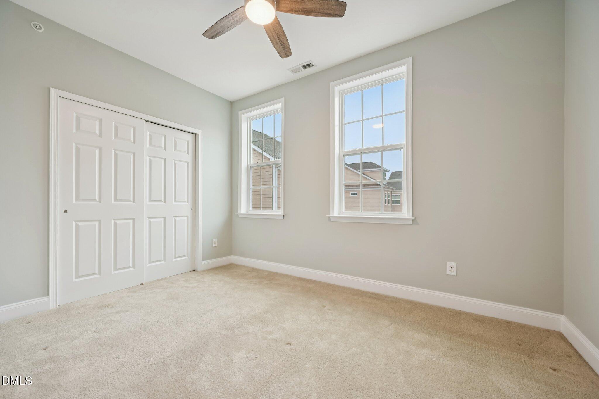 10510 Sablewood Drive, Unit 113 Raleigh, NC 27617 - Photo 31 of 38 an empty room with windows and chandelier fan