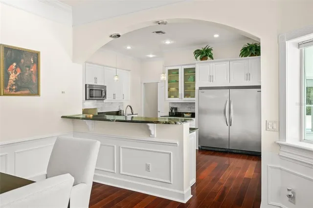 a kitchen with stainless steel appliances granite countertop a stove and white cabinets