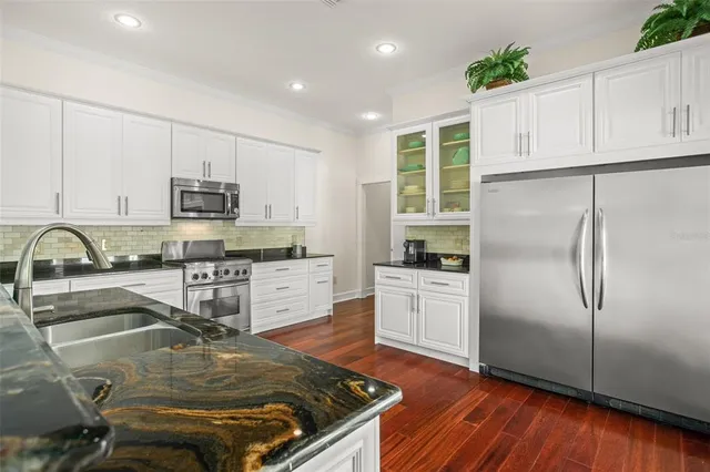 a kitchen with stainless steel appliances granite countertop a stove and a sink