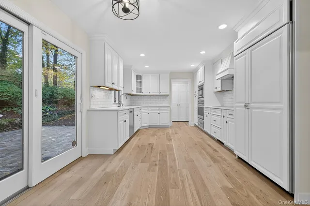 a open kitchen with white cabinets and wooden floor
