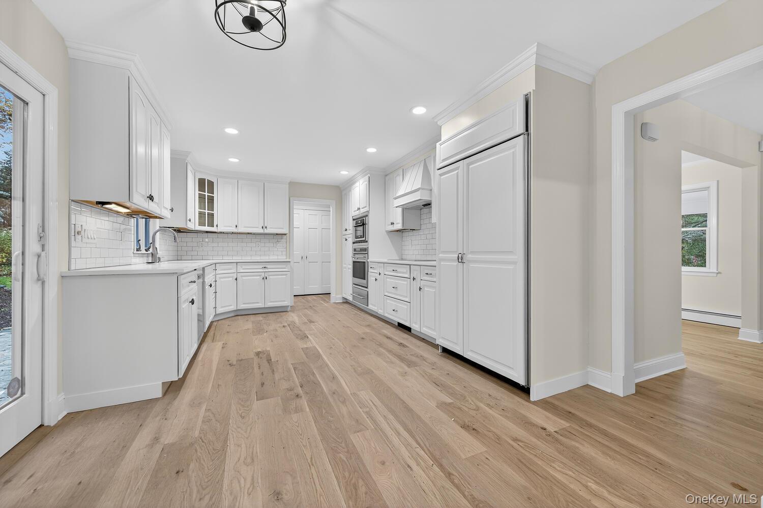 43 Edcris Lane Huntington, NY 11724 - Photo 16 of 37 a kitchen with wooden floors and white appliances