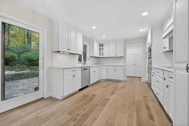 a large kitchen with stainless steel appliances granite countertop a lot of counter space and wooden floors