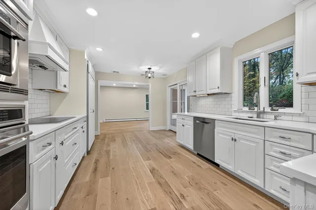 a large kitchen with stainless steel appliances granite countertop a lot of counter space and wooden floors