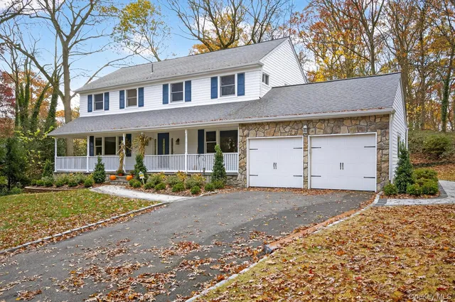a view of a house with a yard and large tree