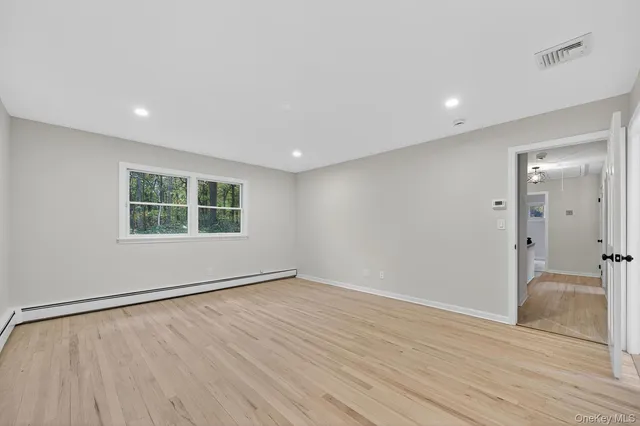 wooden floor in an empty room with a window