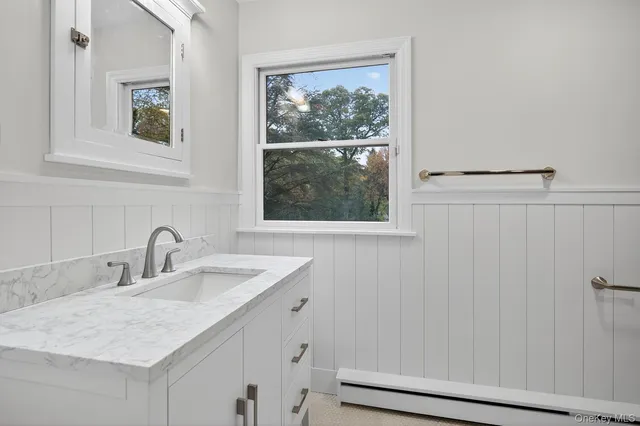 a bathroom with a granite countertop sink and a window