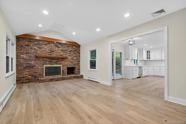 an empty room with wooden floor and fireplace