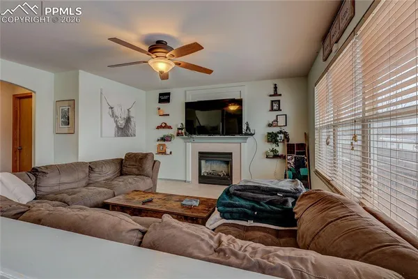 a living room with furniture a flat screen tv and a fireplace
