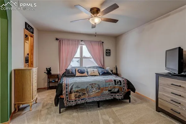 a bedroom with a bed and a flat tv screen on the dresser