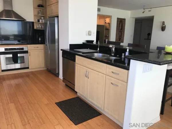 a kitchen with granite countertop a sink and a stove top oven