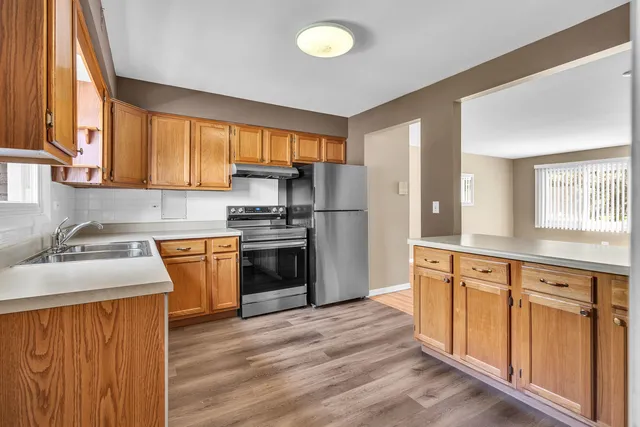 a kitchen with granite countertop a sink stainless steel appliances and cabinets