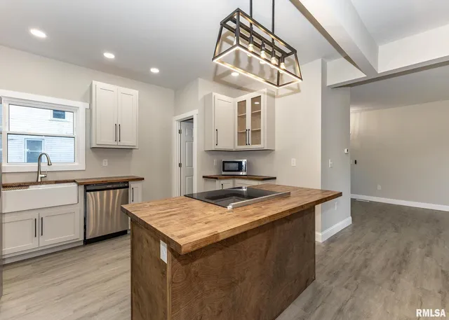 a kitchen with stainless steel appliances granite countertop a sink and a refrigerator