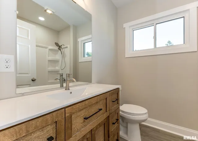 a bathroom with a sink a toilet and shower