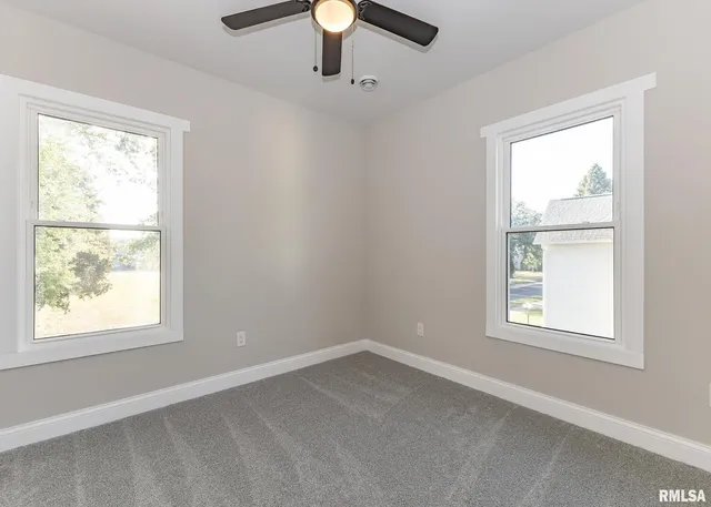 an empty room with closet and fan