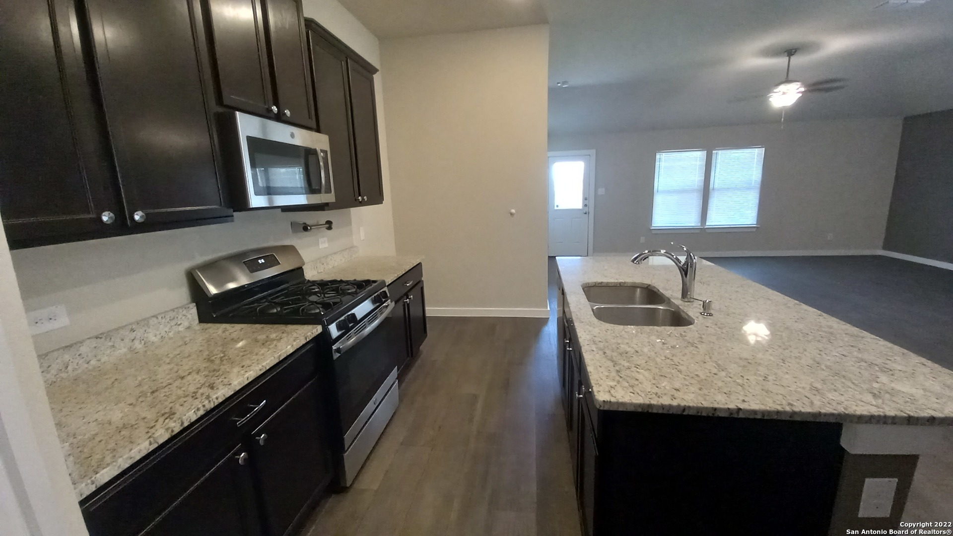 10571 Pablo Way Converse, TX 78109 - Photo 22 of 48 a kitchen with granite countertop stainless steel appliances a sink stove top oven and cabinets