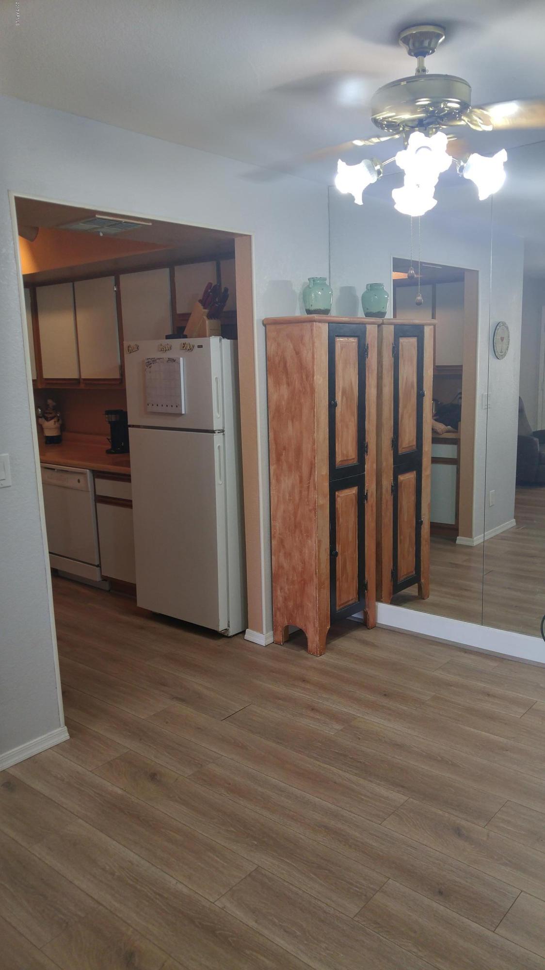 1340 North Recker Road, Unit 219 Mesa, AZ 85205 - Photo 17 of 41 a view of a kitchen with a refrigerator a ceiling fan and wooden floor