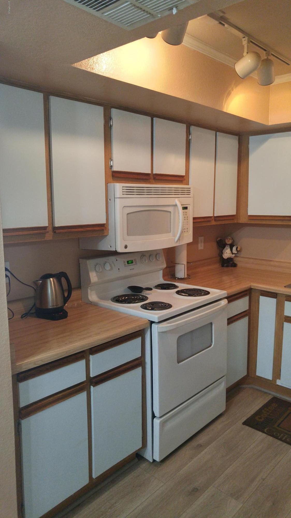 1340 North Recker Road, Unit 219 Mesa, AZ 85205 - Photo 20 of 41 a white stove top oven sitting inside of a kitchen