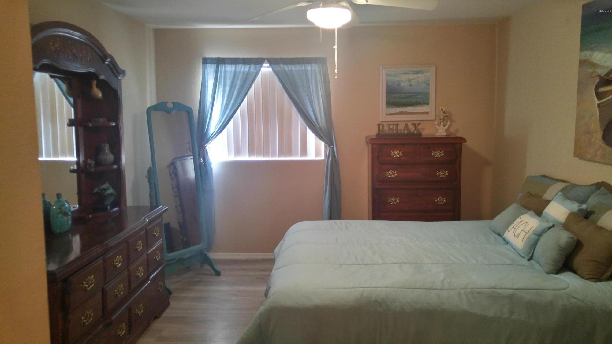 1340 North Recker Road, Unit 219 Mesa, AZ 85205 - Photo 26 of 41 a bedroom with a bed and a mirror on the dresser