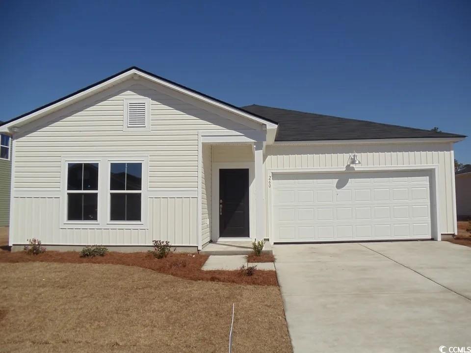 View of front of property featuring an attached garage and concrete driveway
