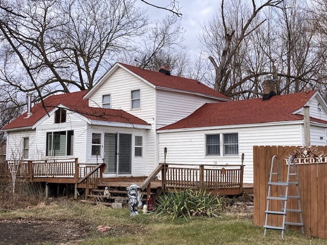 23424 West Coal City Road Wilmington, IL 60481 - Photo 4 of 15 a white house that has a small yard and couches chairs with wooden fence