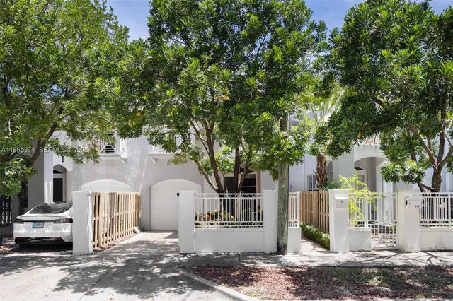 a front view of a house with a tree